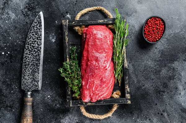 Raw Whole Tenderloin kalvkött på en trälåda med örter. Svart bakgrund. Ovanifrån — Stockfoto