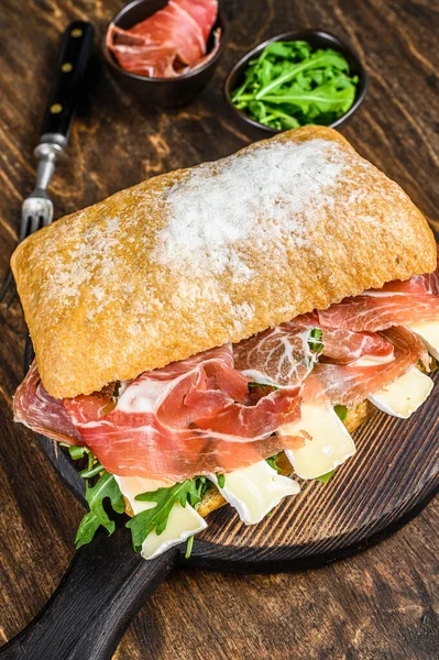 Jamon Ham Sandwich su pane ciabatta con rucola e brie di camembert. sfondo in legno. Vista dall'alto — Foto Stock