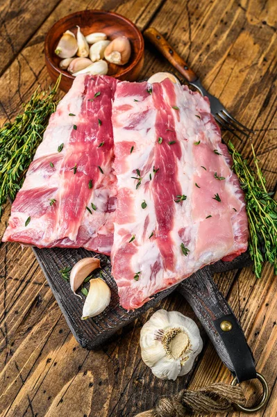 Tahtada kekik ve sarımsaklı taze domuz pirzolası. Ahşap arka plan. Üst görünüm