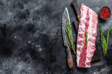 Taze çiğ domuz pirzolası. Kesme tahtasındaki baharatlı ve bıçaklı. Siyah arka plan. Üst Manzara. Boşluğu kopyala