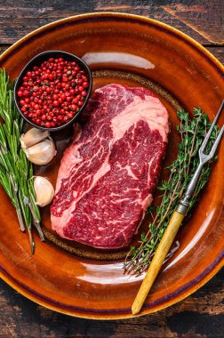 Kırsal bir tabakta siyah angus bifteği. Koyu ahşap arka plan. Üst görünüm