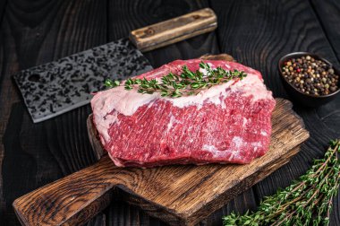 Kasapta satırla kesilmiş taze Raw Round sığır eti. Siyah ahşap arka plan. Üst görünüm