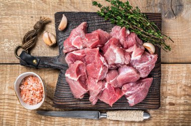 Tahta bir kasap tahtasında baharatlı taze çiğ domuz eti. Ahşap arka plan. Üst görünüm