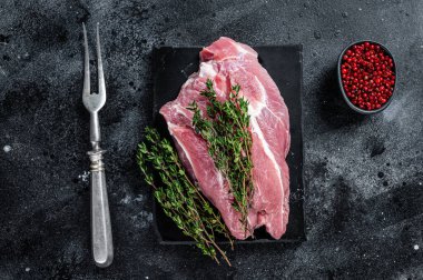 Misket tahtasında kesilmiş çiğ domuz eti. Siyah arka plan. Üst görünüm