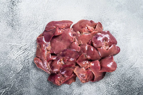 Carne cruda de hígado de pollo en la mesa del carnicero. Fondo blanco. Vista superior —  Fotos de Stock