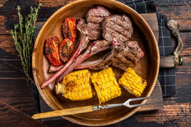 Barbekü kuzu pirzolası, kuzu eti ve ahşap tabakta koyun eti. Koyu ahşap arka plan. Üst görünüm