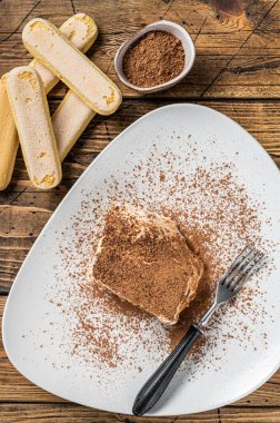 Tabakta kakaolu tiramisu İtalyan keki. Ahşap arka plan. Üst görünüm