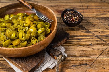 Jalapenolar eski ahşap tabakta turşu ve dilimlenmiş. Ahşap arka plan. Üst Manzara. Boşluğu kopyala