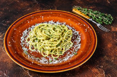 Pesto soslu ve parmesanlı ıspanaklı spagetti. Karanlık arka plan. Üst görünüm