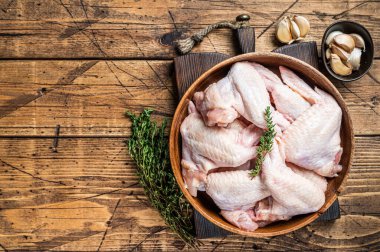 Tahta bir tabakta çiğ tavuk kanadı kekik ve sarımsaklı. Ahşap arka plan. Üst Manzara. Boşluğu kopyala