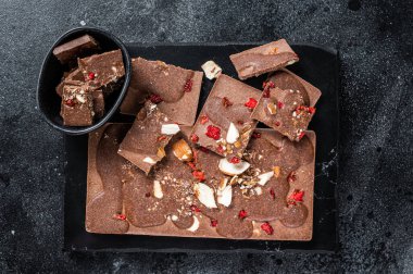 Mermer tahtada el yapımı çikolatalar. Siyah arka plan. Üst görünüm