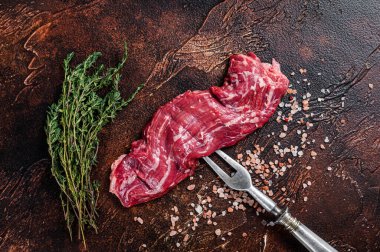 Et çatalında pişmemiş çiğ biftek. Karanlık arka plan. Üst görünüm