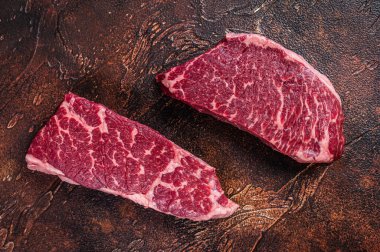Çiğ Denver bifteği, mermer et. Karanlık arka plan. Üst görünüm