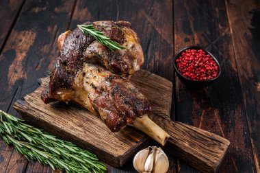 Ahşap kesme tahtasının üzerinde kuzu eti. Koyu ahşap arka plan. Üst görünüm