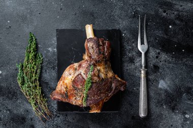 Fırında kuzu kuzu kuzu budu ve kekik. Siyah arka plan. Üst görünüm