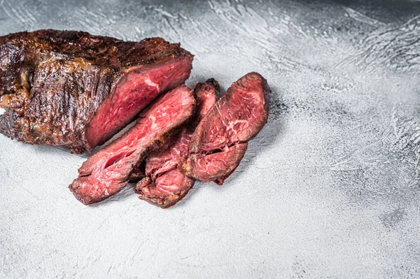 Pečený věšák nebo Onglet nakrájeli hovězí steak na stůl. Bílé pozadí. Top View. Kopírovat prostor — Stock fotografie