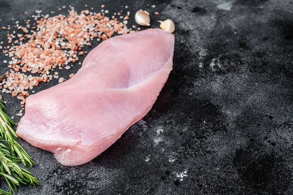 Ωμό κρέας φιλέτου στήθους γαλοπούλας σε κρεοπωλείο με δεντρολίβανο και αλάτι. Μαύρο φόντο. Στο Top View. Αντιγραφή χώρου — Φωτογραφία Αρχείου