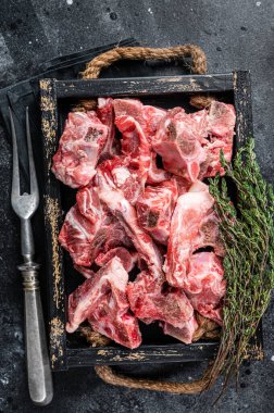 Tahta tepside çiğ et ve kemik. Siyah arka plan. Üst Görünüm