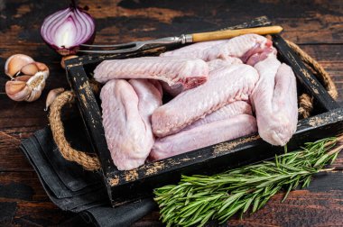 Taze çiğ ördek ve tepside tavuk kanadı. Koyu ahşap arka plan. Üst görünüm