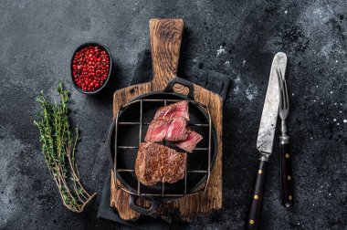 Izgarada ızgara fileminyon biftek. Siyah arka plan. Üst görünüm