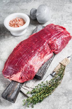 Taze kanat ya da çiğ bifteği ahşap tahtada otlarla çırp. Gri arka plan. Üst görünüm