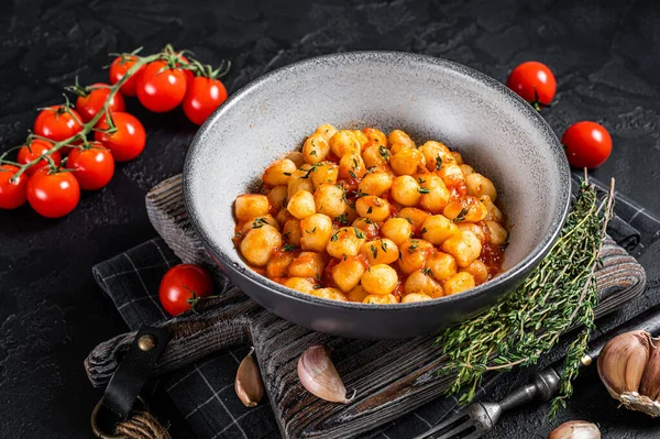 Gnocchi Kartoffelnudeln mit Tomatensauce und Thymian. Schwarzer Hintergrund. Ansicht von oben — Stockfoto
