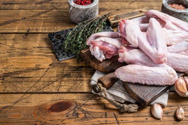 Kasap tahtasında çiğ ördek ya da tavuk kanadı. Koyu ahşap arka plan. Üst Manzara. Boşluğu kopyala