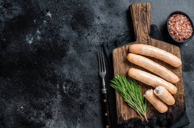 Ahşap bir tahtanın üzerinde kızarmış tavuk ve hindi sosisi. Siyah arka plan. Üst Manzara. Boşluğu kopyala