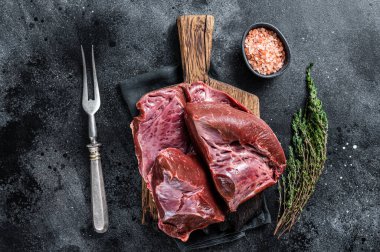 Çiğ sığır eti ya da kasap tahtasındaki dana kalbi. Siyah arka plan. Üst Görünüm