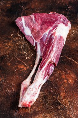 Kemikteki çiğ keçi eti. Karanlık arka plan. Üst görünüm