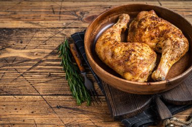 Ahşap bir tabakta ızgara tavuk budu ve şifalı otlar. Ahşap arka plan. Üst Manzara. Boşluğu kopyala