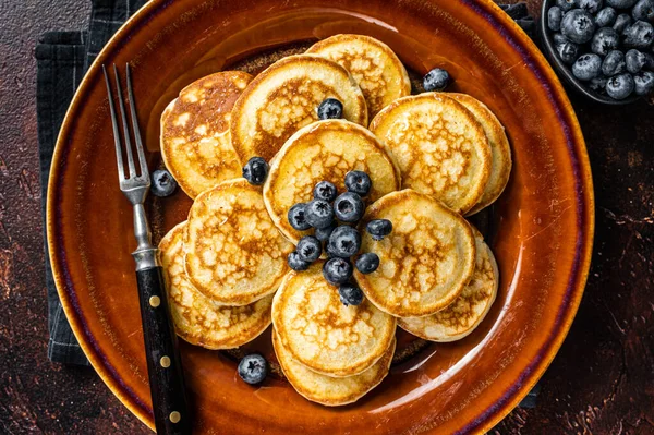 Piring dengan pancake dengan blueberry segar dan sirup. Latar belakang gelap. Tampilan Atas — Stok Foto