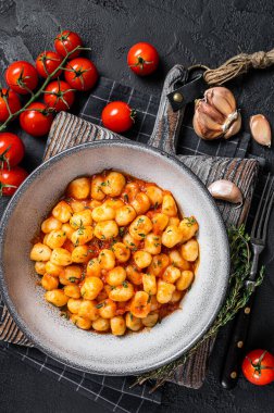 Domates soslu ve kekikli Gnocchi patatesli makarna. Siyah arka plan. Üst görünüm