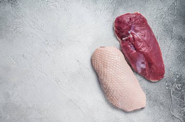 Çiğ ördek göğsü filetosu kasap masasında. Beyaz arka plan. Üst Manzara. Boşluğu kopyala