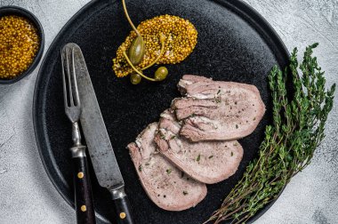 Tabakta dana eti ya da haşlanmış dil dilimleri. Beyaz arka plan. Üst görünüm