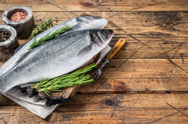 Tahta kesme tahtasının üzerinde biberiyeli taze deniz ürünü. Ahşap arka plan. Üst Manzara. Boşluğu kopyala