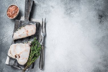 Tahta kesme tahtasının üzerinde çiğ kurt filetosu bifteği. Beyaz arka plan. Üst Manzara. Boşluğu kopyala