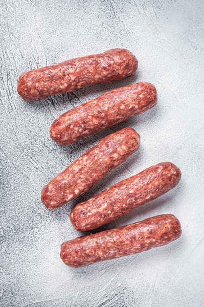 Ωμό βοδινό και αρνίσιο κρέας λουκάνικα κεμπάπ σε ένα τραπέζι χασάπη. Λευκό φόντο. Άνω όψη — Φωτογραφία Αρχείου