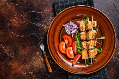 Kır tabağında sebzeli ızgara somon kebabı şiş. Karanlık arka plan. Üst Manzara. Boşluğu kopyala