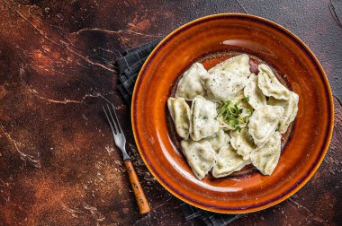 Patatesli, otlu ve tereyağlı Polonya Pierogi köfteleri. Karanlık arka plan. Üst Manzara. Boşluğu kopyala