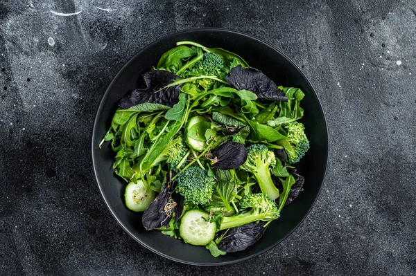 Frische Salatmischung aus Spinat, Rucolablättern, Mangold und Feldsalat mit Gemüse. Schwarzer Hintergrund. Ansicht von oben — Stockfoto