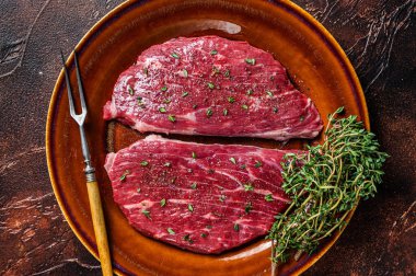 Çiğ biftek ya da kekik ve zeytinyağlı sığır etli sığır filetosu. Karanlık arka plan. Üst görünüm