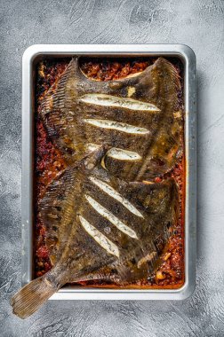 Yemek tepsisinde domates sosunda pişirilmiş Plaice veya Flounder Düz Balık. Beyaz arka plan. Üst görünüm