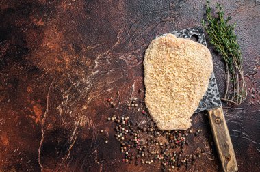 Domuz Raw Escalope ya da et satırında otlu şnitzel. Karanlık arka plan. Üst Manzara. Boşluğu kopyala