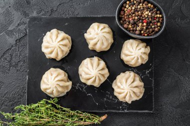 Mermer bir tahtanın üzerinde Çin baozi köftesi. Siyah arka plan. Üst görünüm
