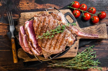 Izgara Tomahawk bifteği ve otlar. Ahşap arka plan. Üst görünüm