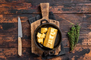 Tavada parmesan peyniri. Karanlık ahşap arka plan. Üst görünüm