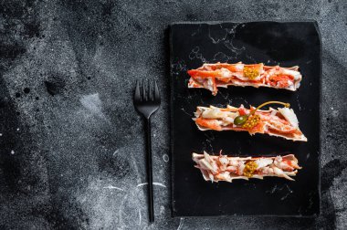 Bitkilerle dolu bir kılıfta yengeç bacağı eti. Siyah arka plan. Üst Manzara. Boşluğu kopyala