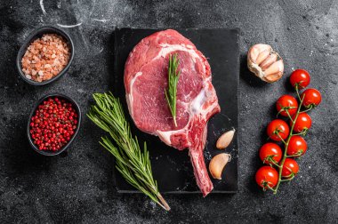 Çiğ kaburga ya da baharatlı Tomahawk bifteği pişirmek. Siyah arka plan. Üst görünüm