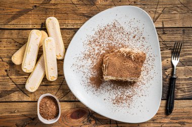 Tabakta kakaolu tiramisu İtalyan keki. Ahşap arka plan. Üst görünüm